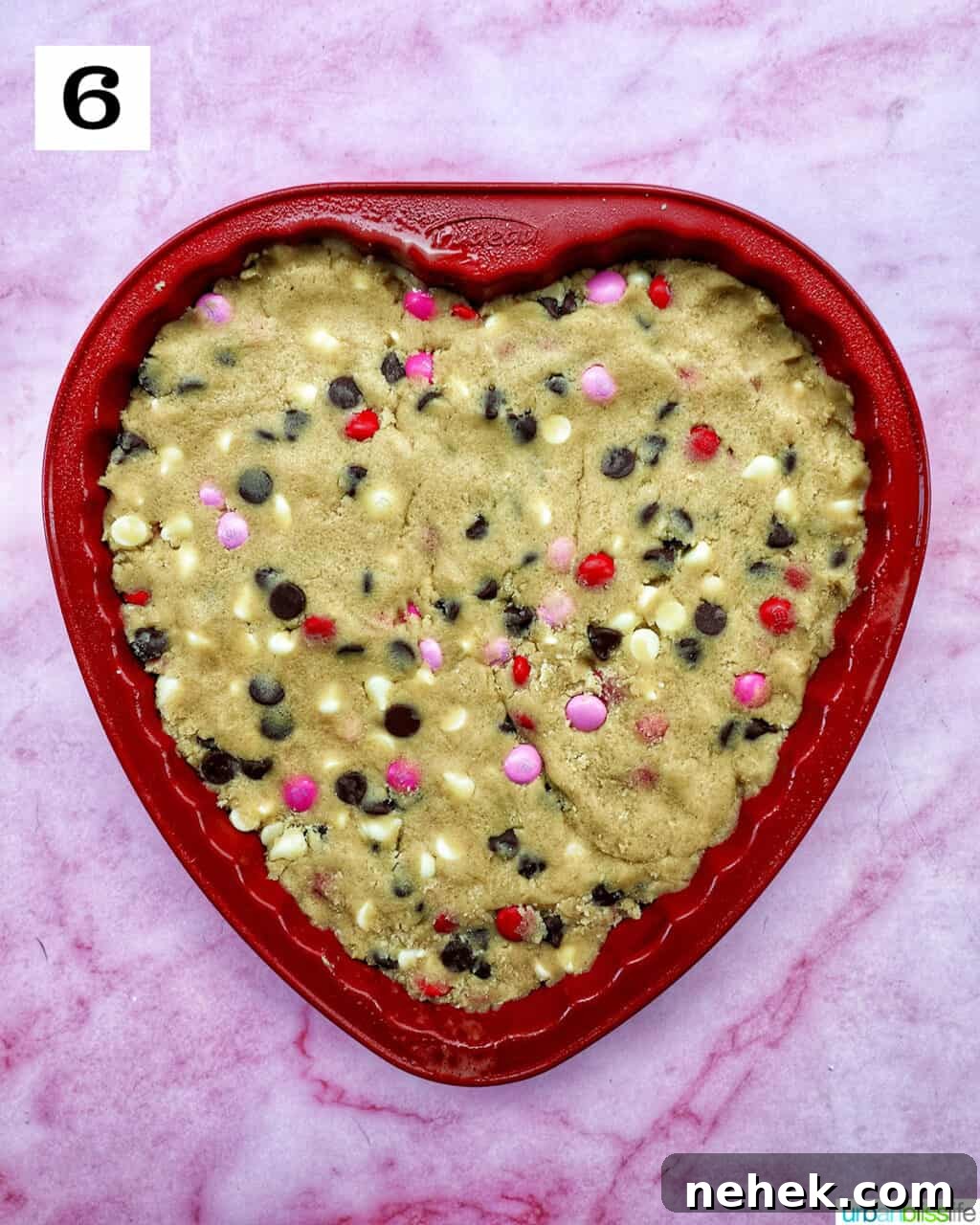 A heart-shaped Valentine's Day cookie cake with red, white, and pink M & M decorations.