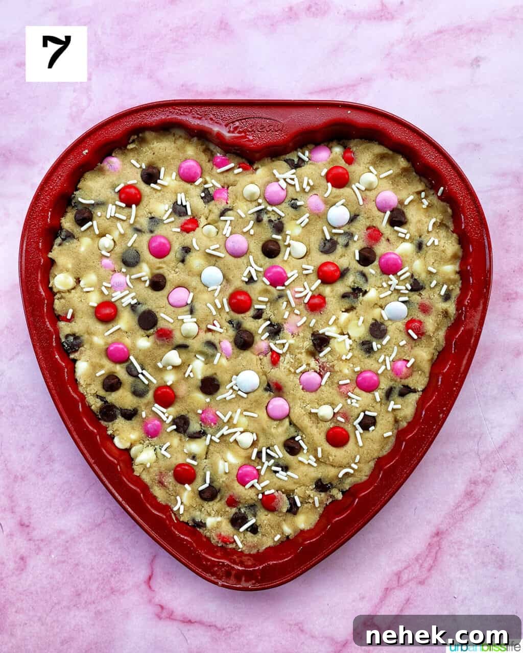 A heart-shaped Valentine's Day cookie cake with red, white, and pink M & M decorations.
