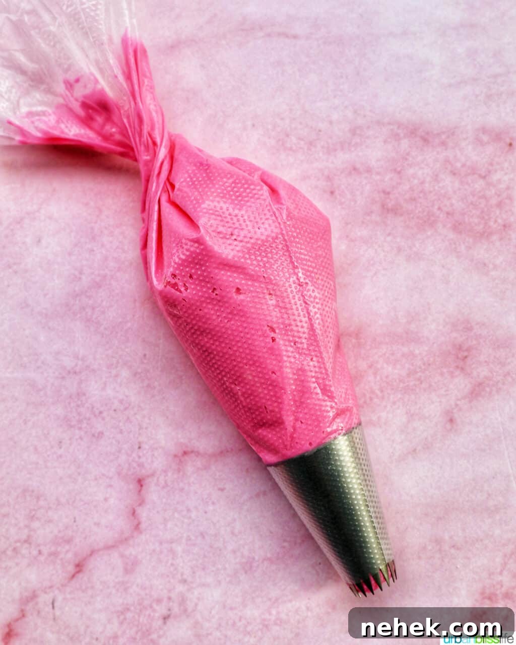 pastry bag with bright pink frosting inside.
