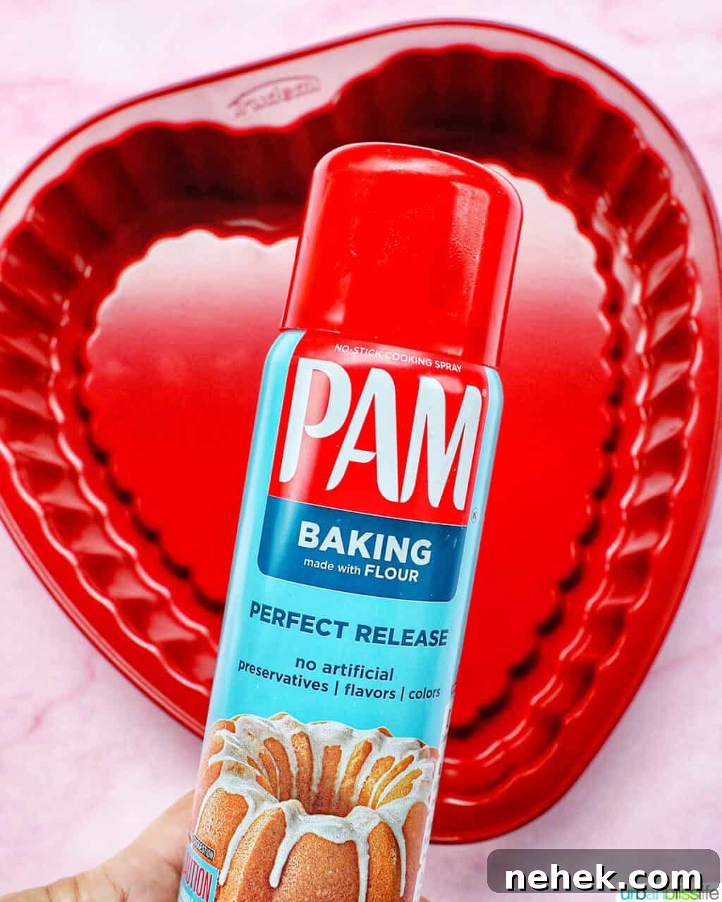 Pam baking spray over a red heart-shaped baking pan.