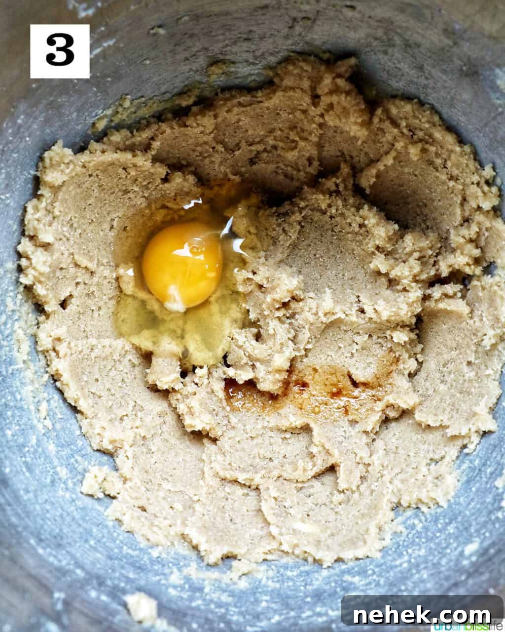 cookie batter with an egg in a stand mixer bowl.