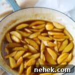 Caramelized peaches in enameled skillet.