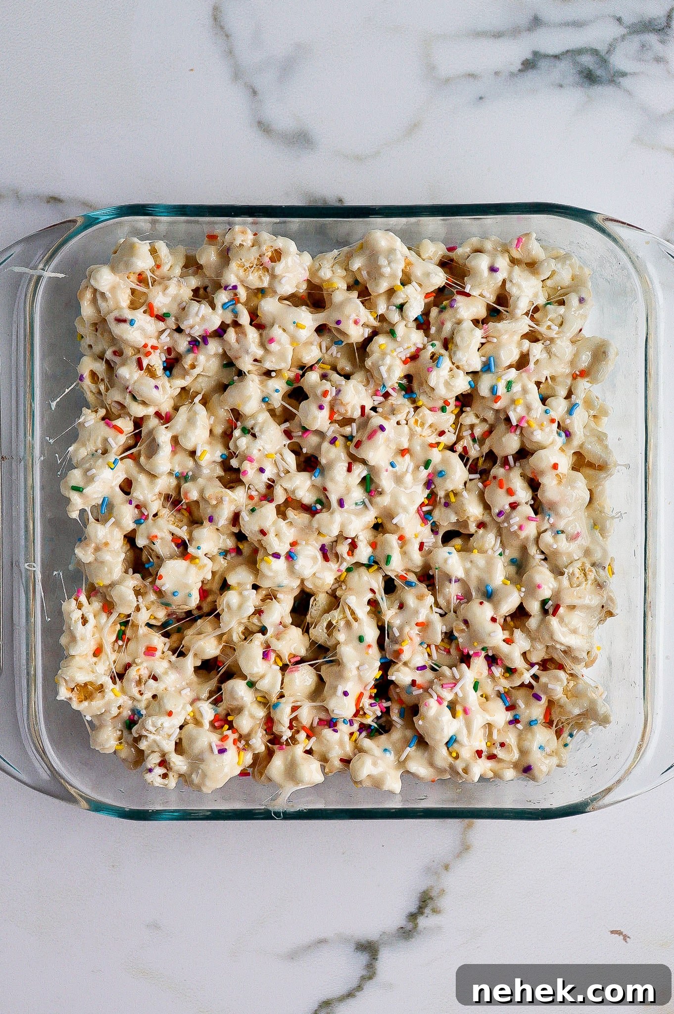 top down view of funfetti marshmallow popcorn treats in glass baking dish