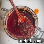 Wooden spoon in a jar of chilli oil.