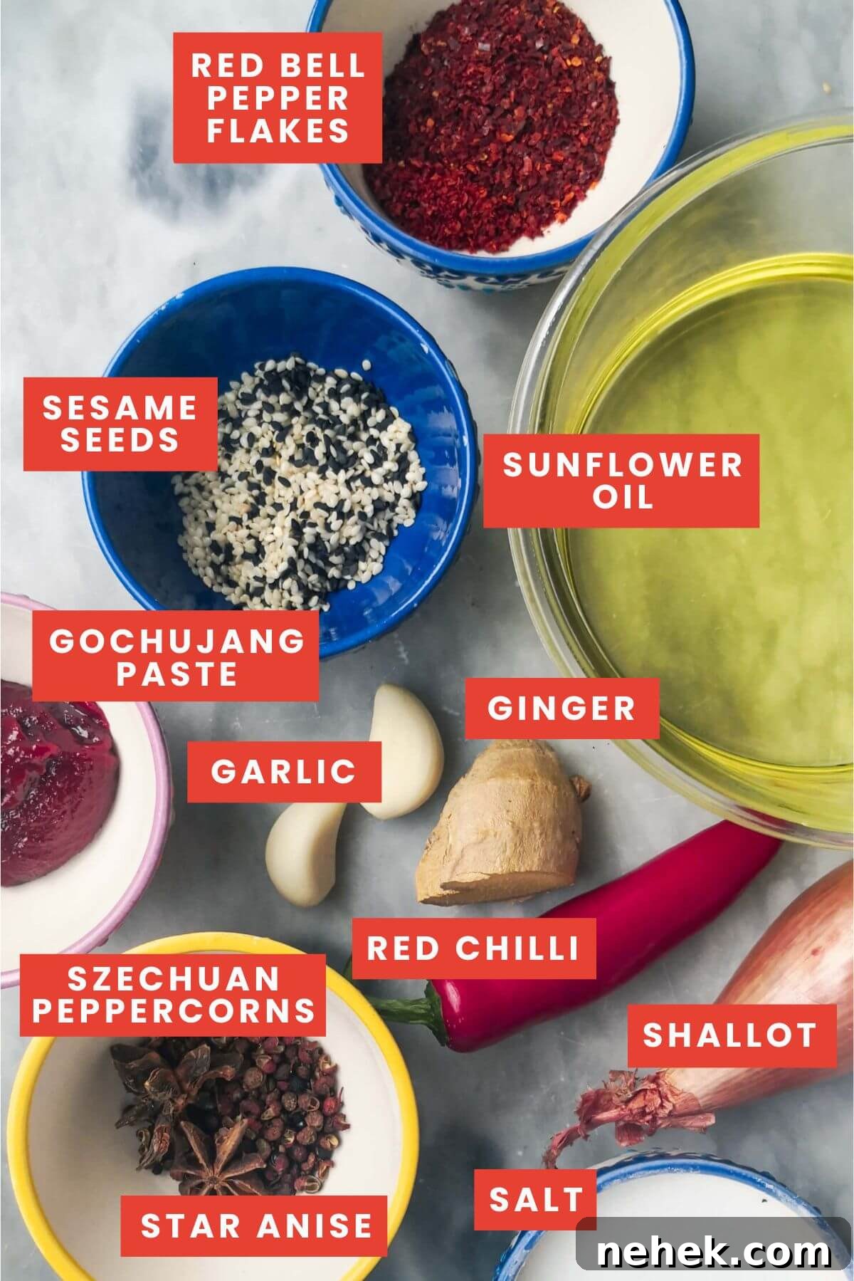 Ingredients for chilli oil laid out on a grey marble background.