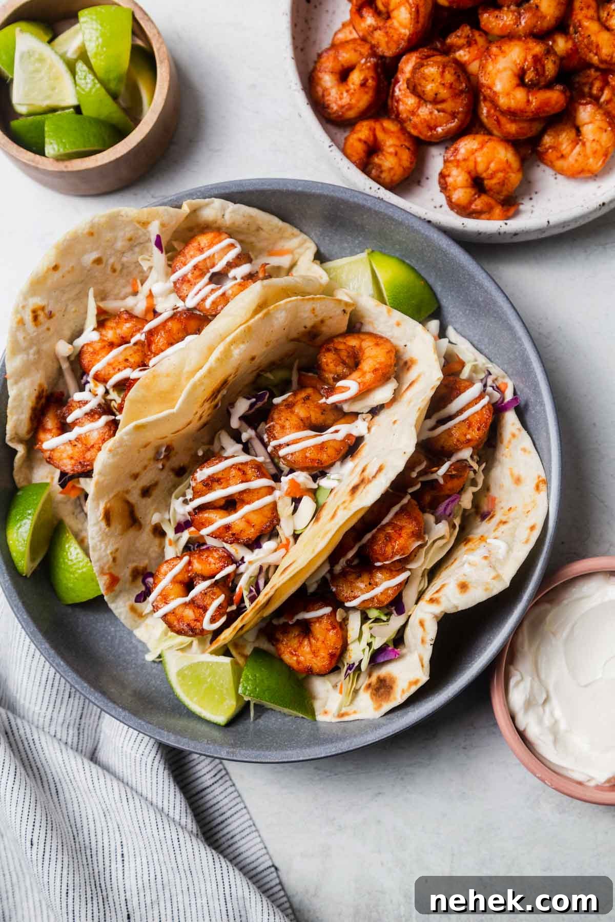 Crispy Air Fryer Shrimp Tacos with Lime Slaw 2 air fryer shrimp tacos in a plate with lime wedges.