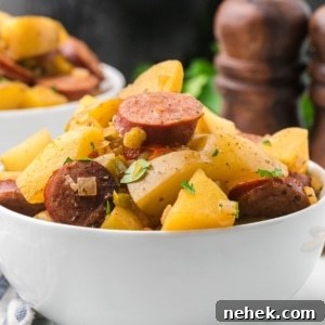 a bowl of Crockpot Sausage Potatoes stacked high with ingredients.