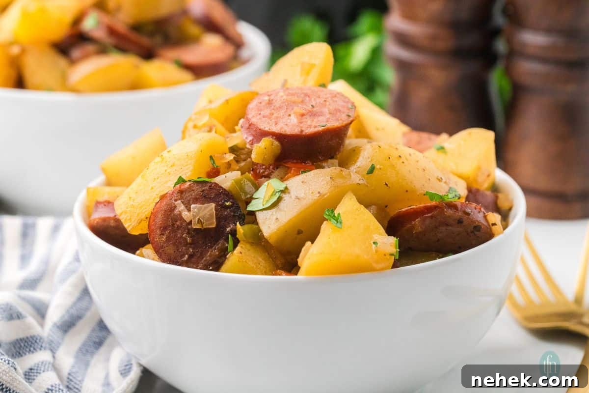 a horizontal image of a bowl of sausages and potatoes in slow cooker