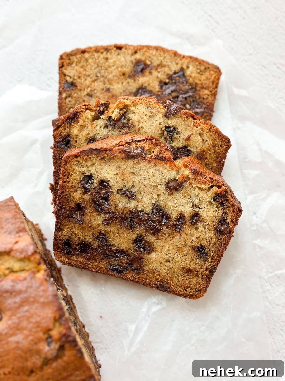 three slices of browned butter banana chocolate chip bread stacked on top of each other.