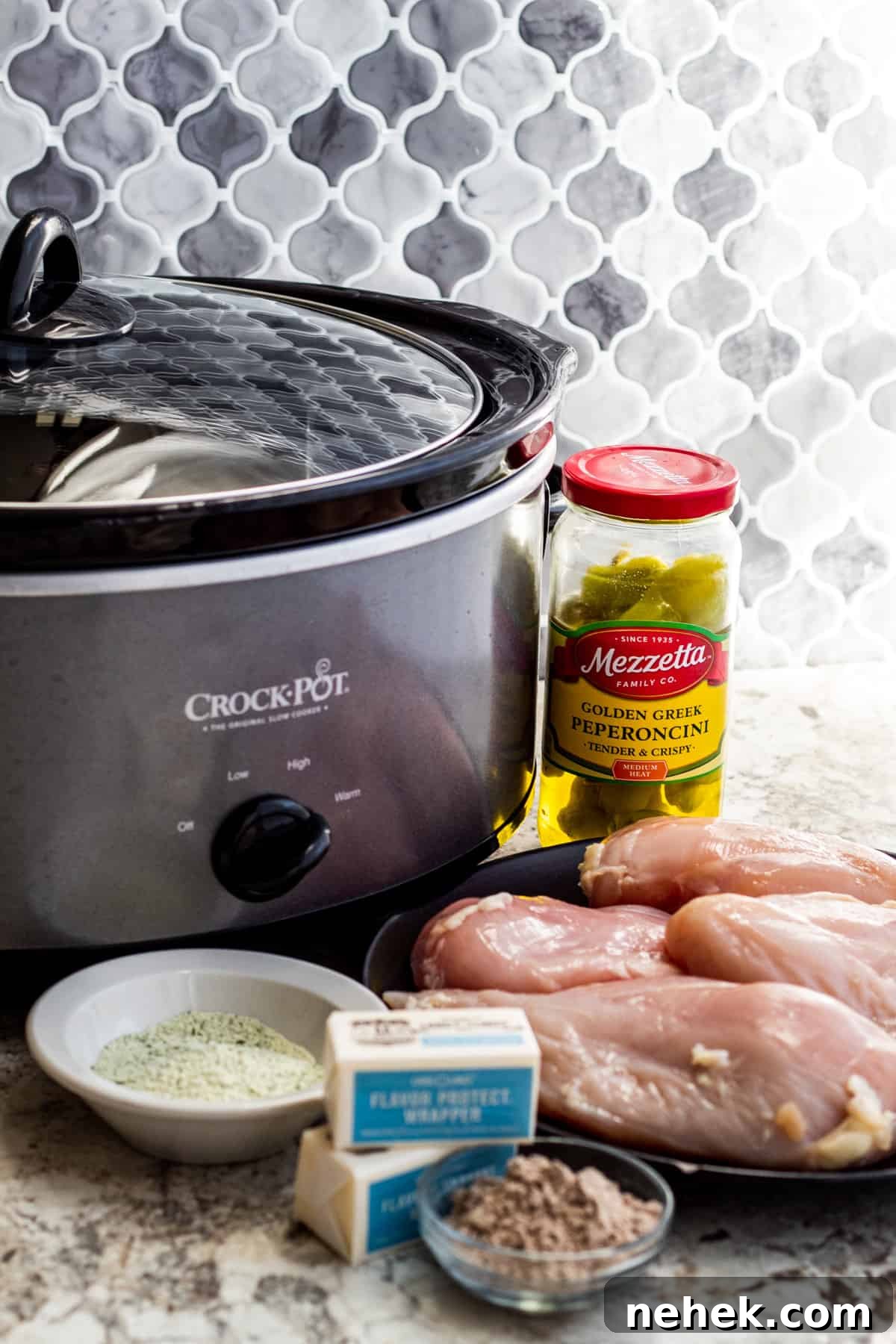Slow-Cooker Mississippi Chicken with Creamy Sauce and Peppers 3 Ingredients and crockpot laid out on white counter on plates and bowls.