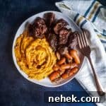 White plate with short ribs and sides on it.