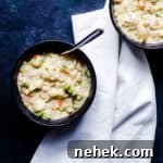 Overhead shot of two bowls of chicken and dumplings on a blue counter.