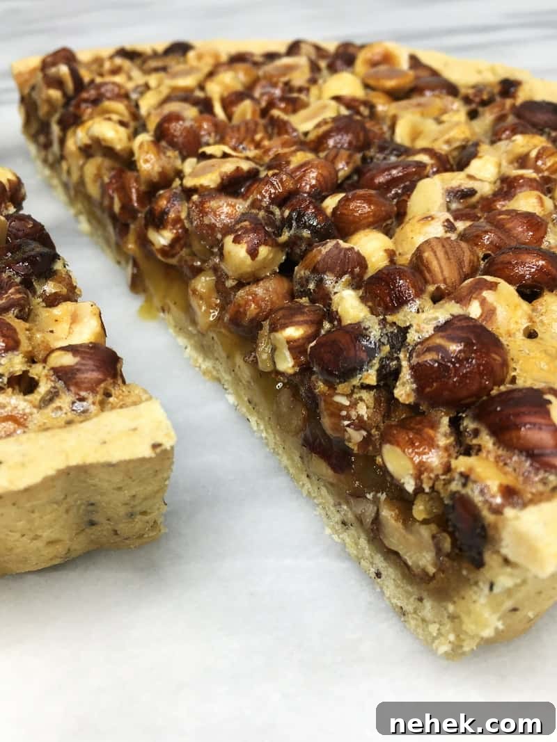 Hazelnut pie cut into two haves on a marble board