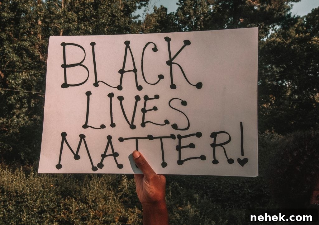 7 Practical Actions Individuals Can Take to Fight Racism 3 Black hand holding a "Black Lives Matter" placard