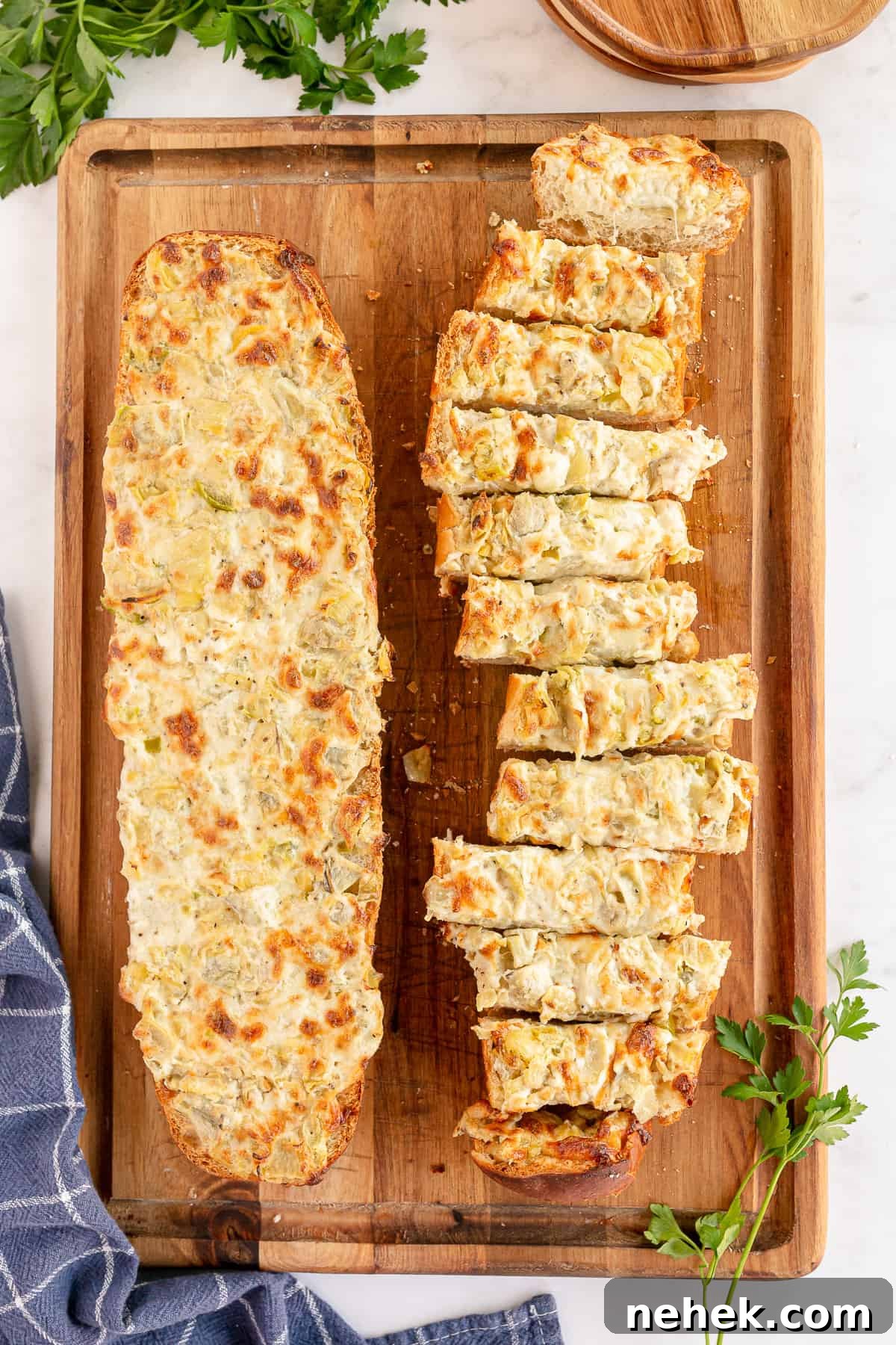 Sliced artichoke bread on a cutting board shot from over the top.