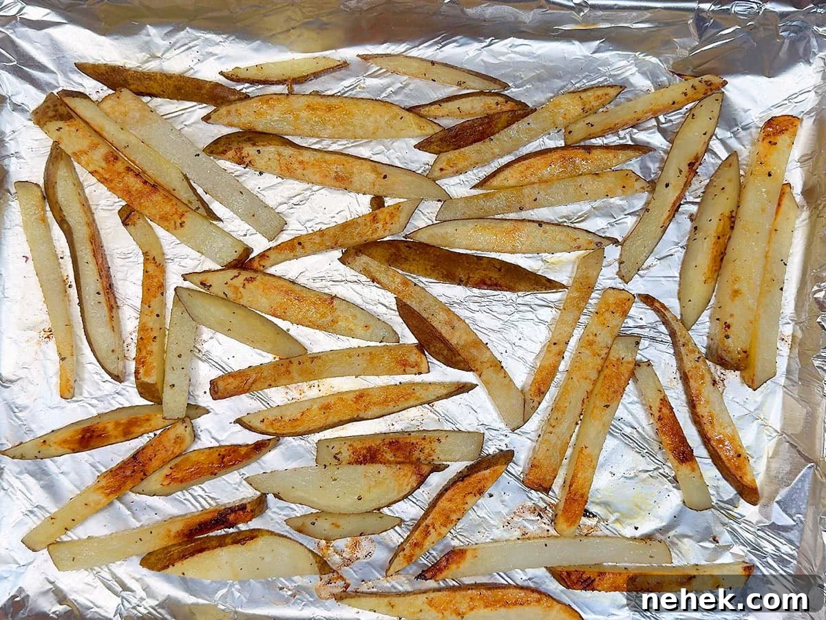 Crispy Oven-Baked French Fries Recipe for Perfect Crunch 8 Cooked oven baked French fries on a foiled lined and greased cookie sheet.