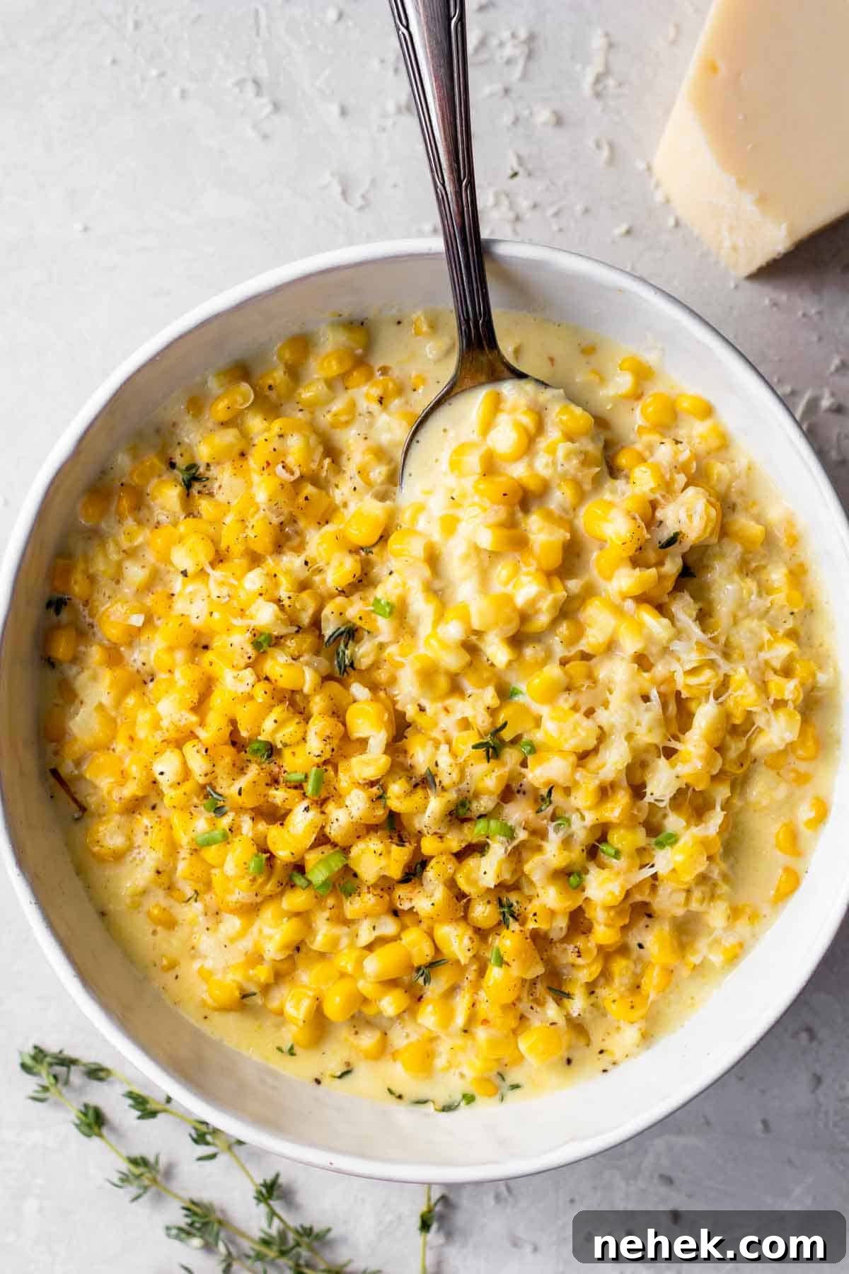 Bowl of creamed corn served with a spoon.