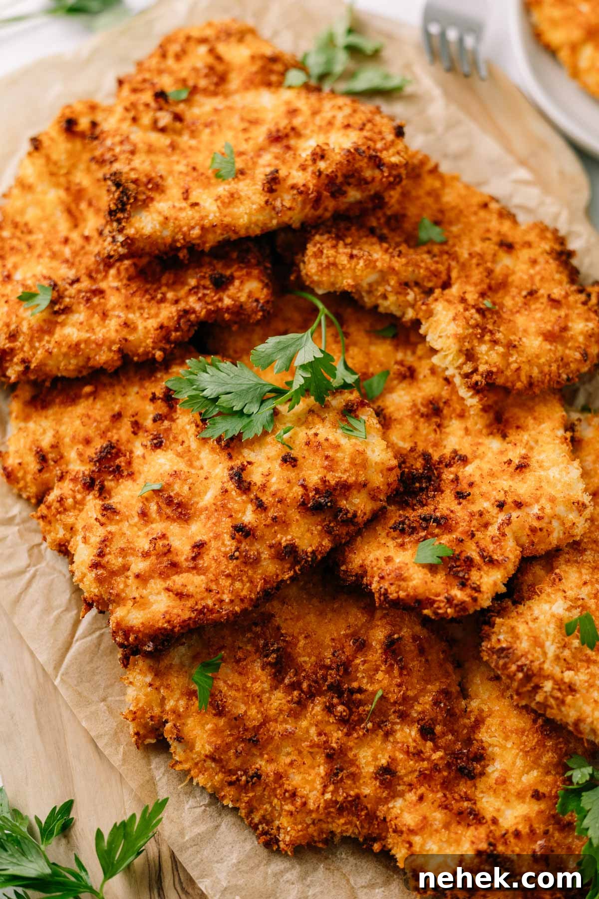 a plate of crispy, closeup of crispy, golden air fryer chicken cutlets on brown paper