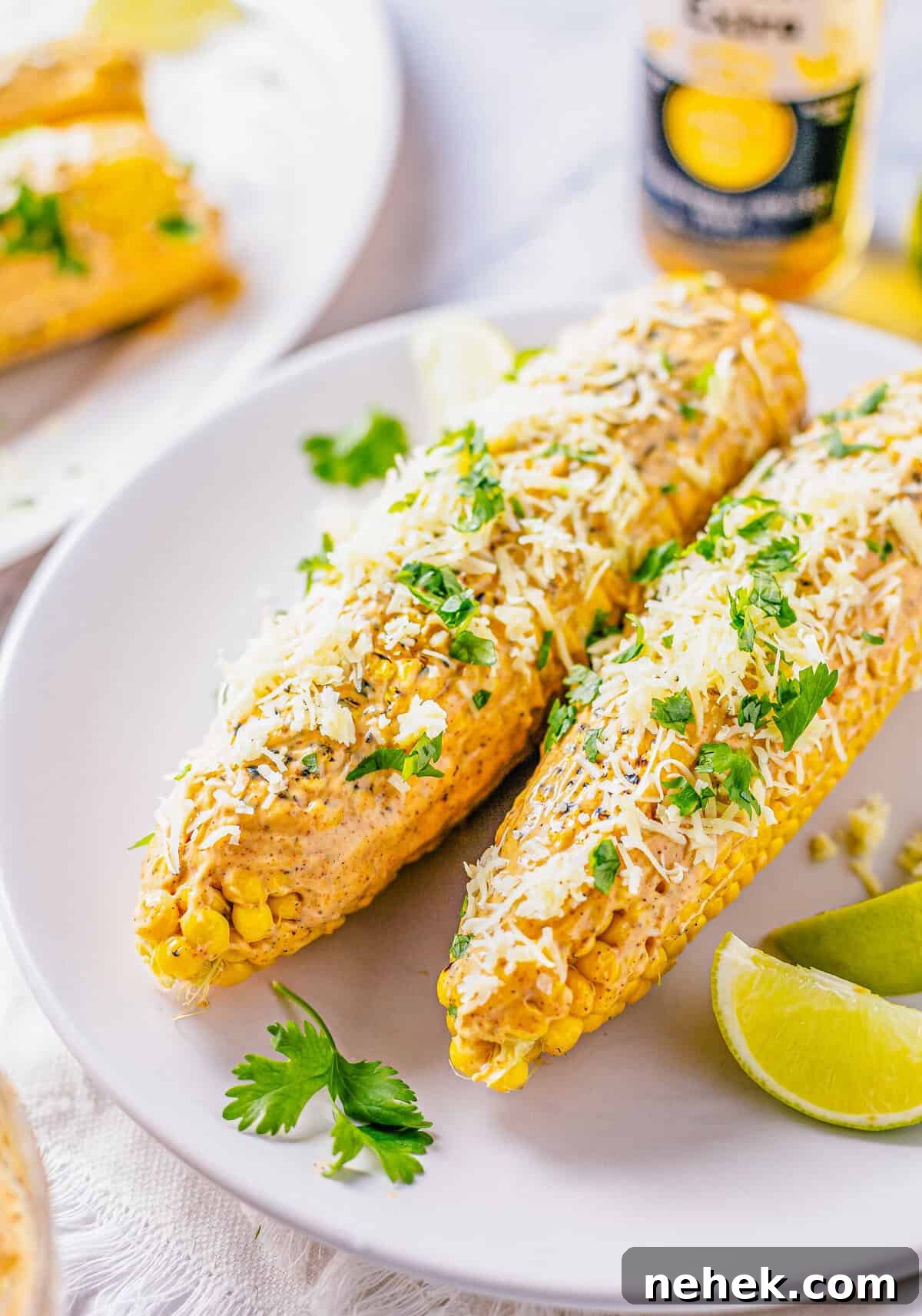 Smoky Chipotle Street Corn (Mexican Elote) Recipe 7 Two ears of corn garnished on white plate