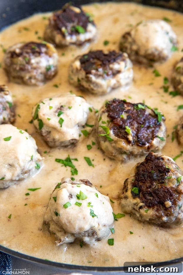 paleo almond flour beef meatballs in a skillet with creamy dairyfree gravy