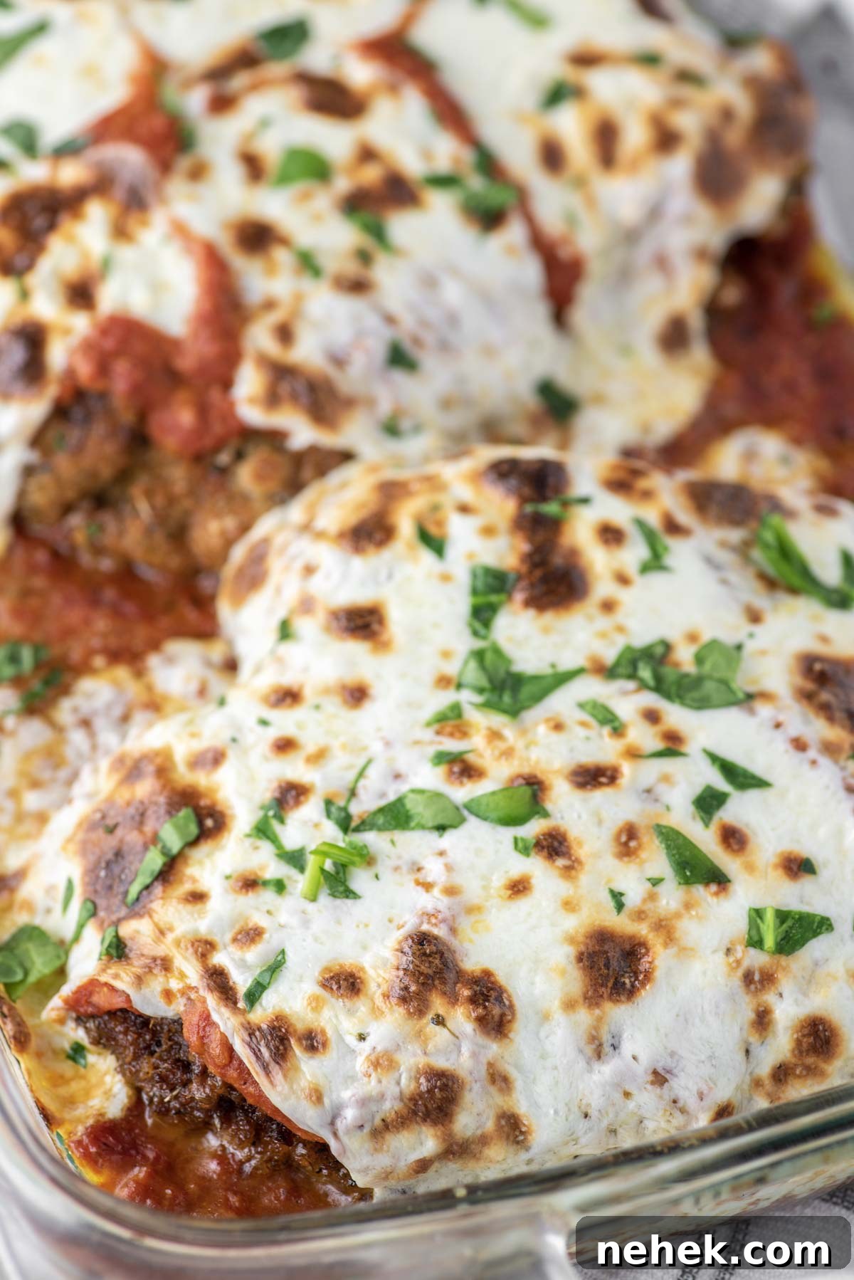 Breaded chicken parmesan in glass dish.