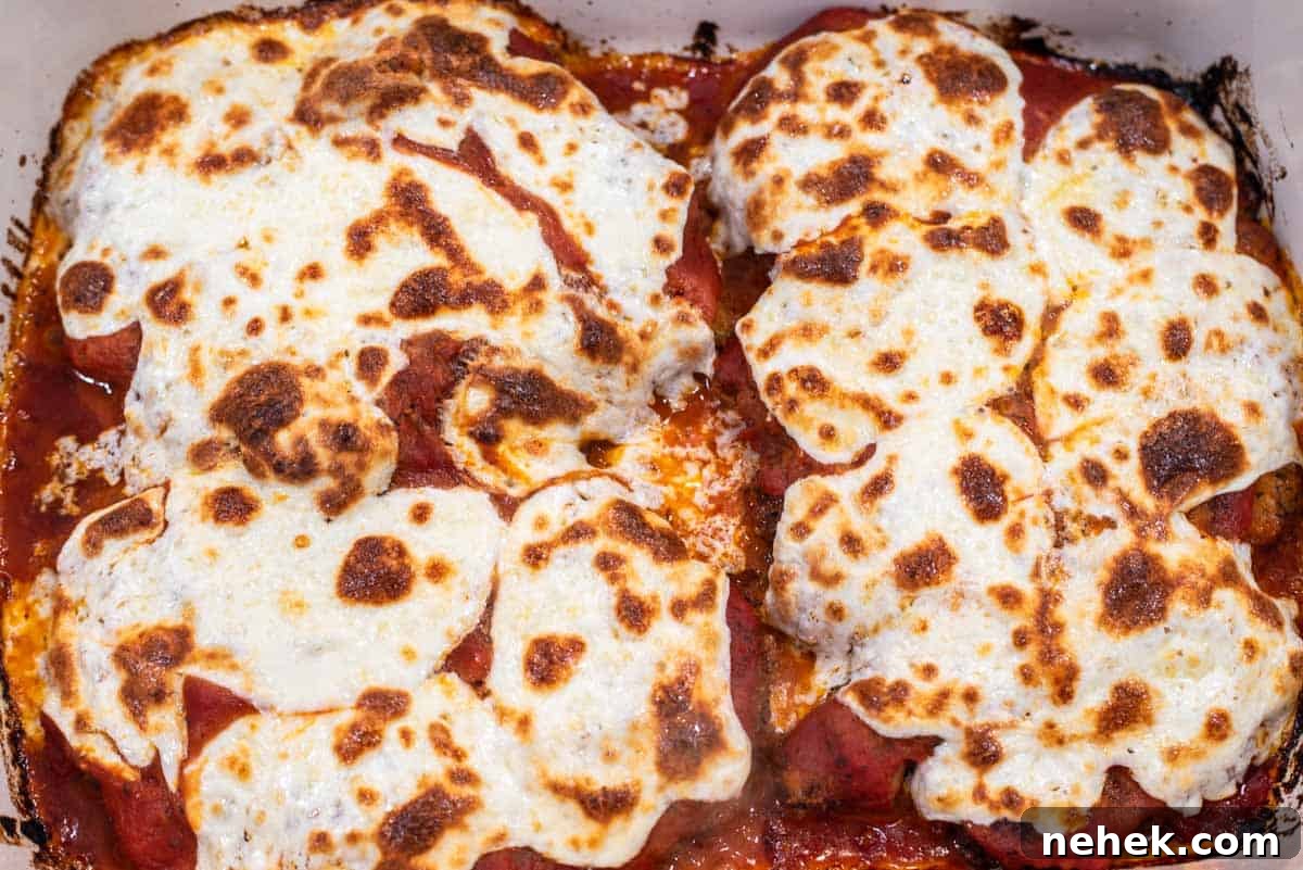 Baked chicken parmesan in baking dish.