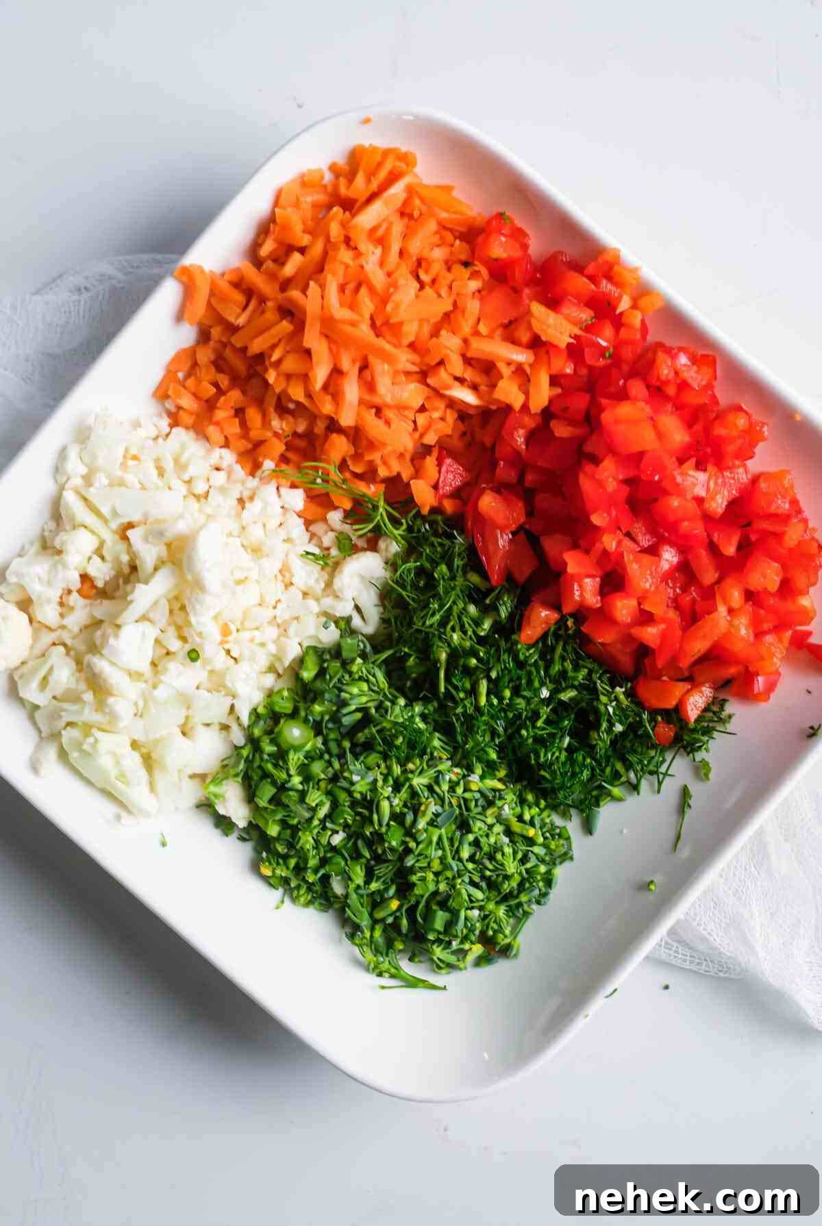 Crunchy Veggie Pinwheels with Cream Cheese and Herbs 5 chopped vegetables on a plate ready to be added to the pinwheel filling mixture