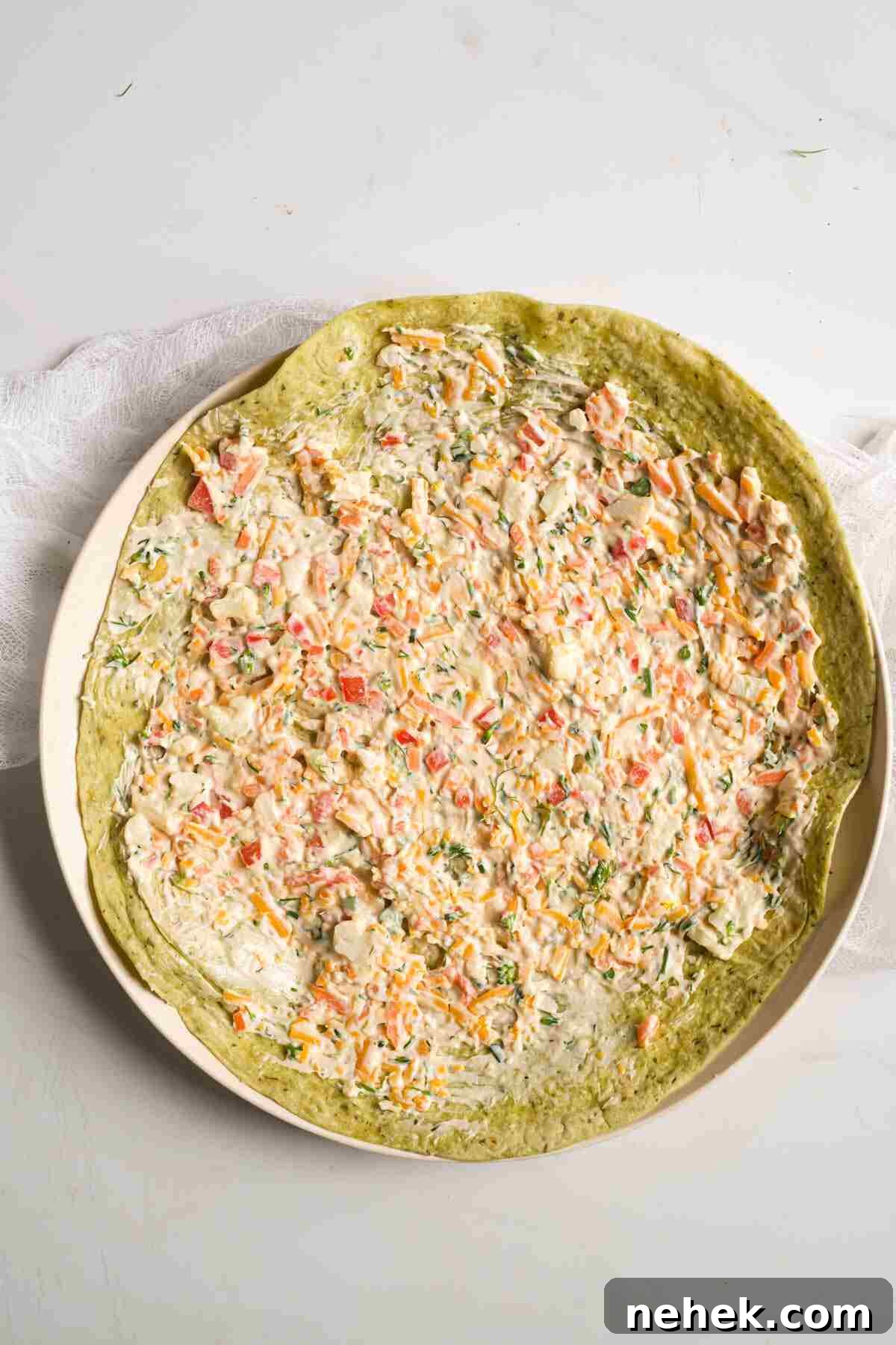 Crunchy Veggie Pinwheels with Cream Cheese and Herbs 7 the filling mixture spread onto one of the tortillas