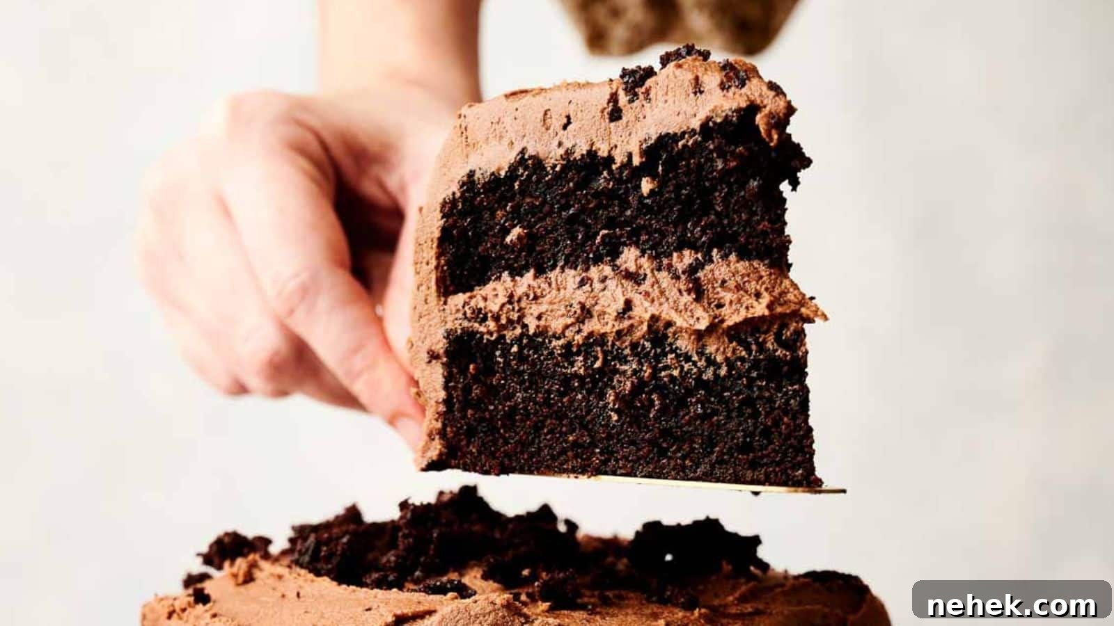15 Delicious Easter Recipes to Make Your Celebration Shine 16 A person holding a slice of chocolate layer cake with frosting from a chocolate cake recipe.