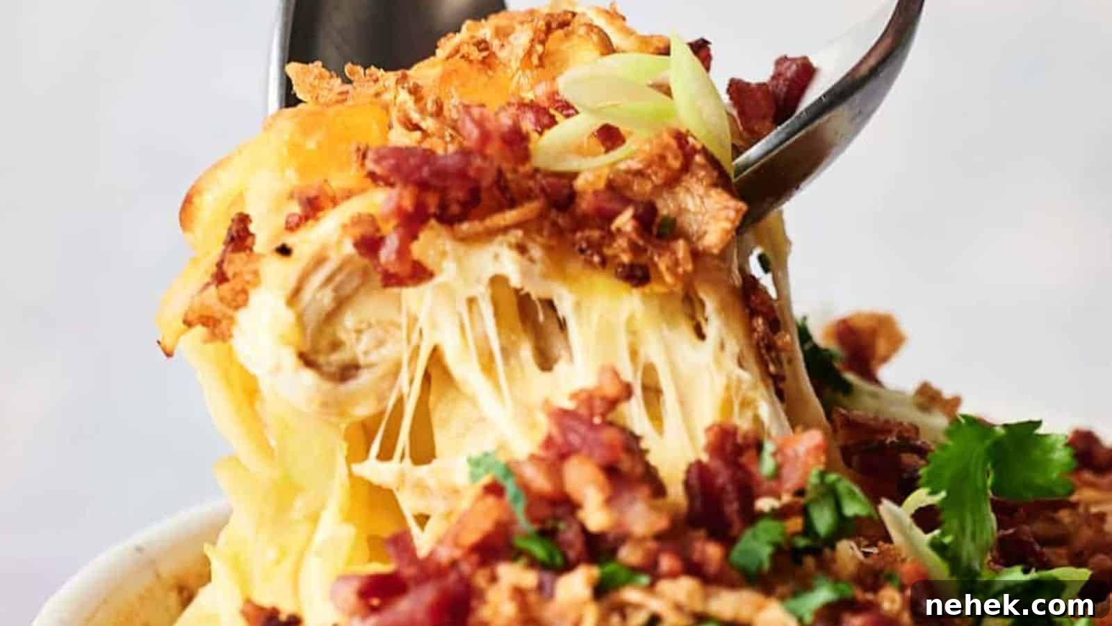 15 Delicious Easter Recipes to Make Your Celebration Shine 9 A fork lifting a cheesy bite from a bowl of chicken casserole topped with bacon and breadcrumbs.