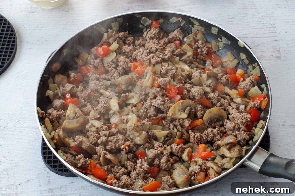 Low-Carb Pizza Casserole with Veggies and Mozzarella 6 browned ground beef with vegetables in skillet