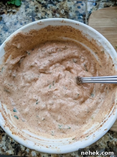 The finished healthy salad dressing in a white bowl with a spoon