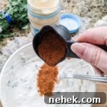 Marie dropping some of the taco seasoning into the Lighter Southwestern Buttermilk Ranch