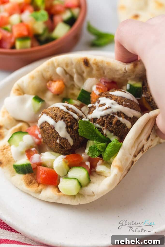 Gluten-free falafel wrap topped with tahini sauce dripped over the top.