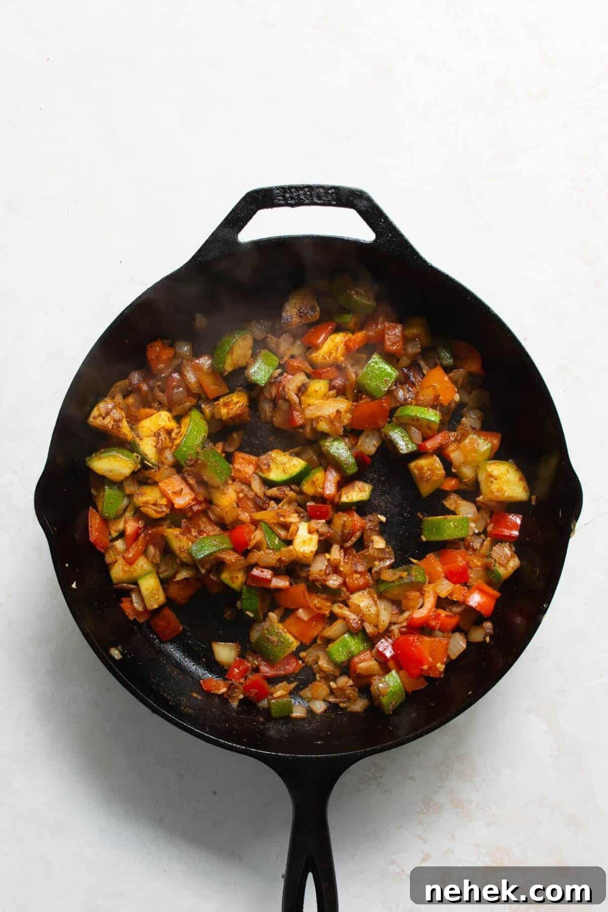 Adding cumin, paprika, ginger, and chili flakes to sautéed vegetables for shakshuka