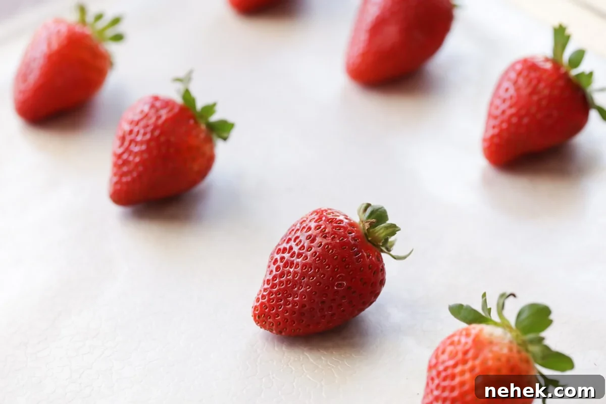 Juicy and sweet strawberry ghosts are spooky and delicious!! Here is a simple and quick tutorial on how to make these Boo-tiful treats. washed and cleaned strawberries on a tray