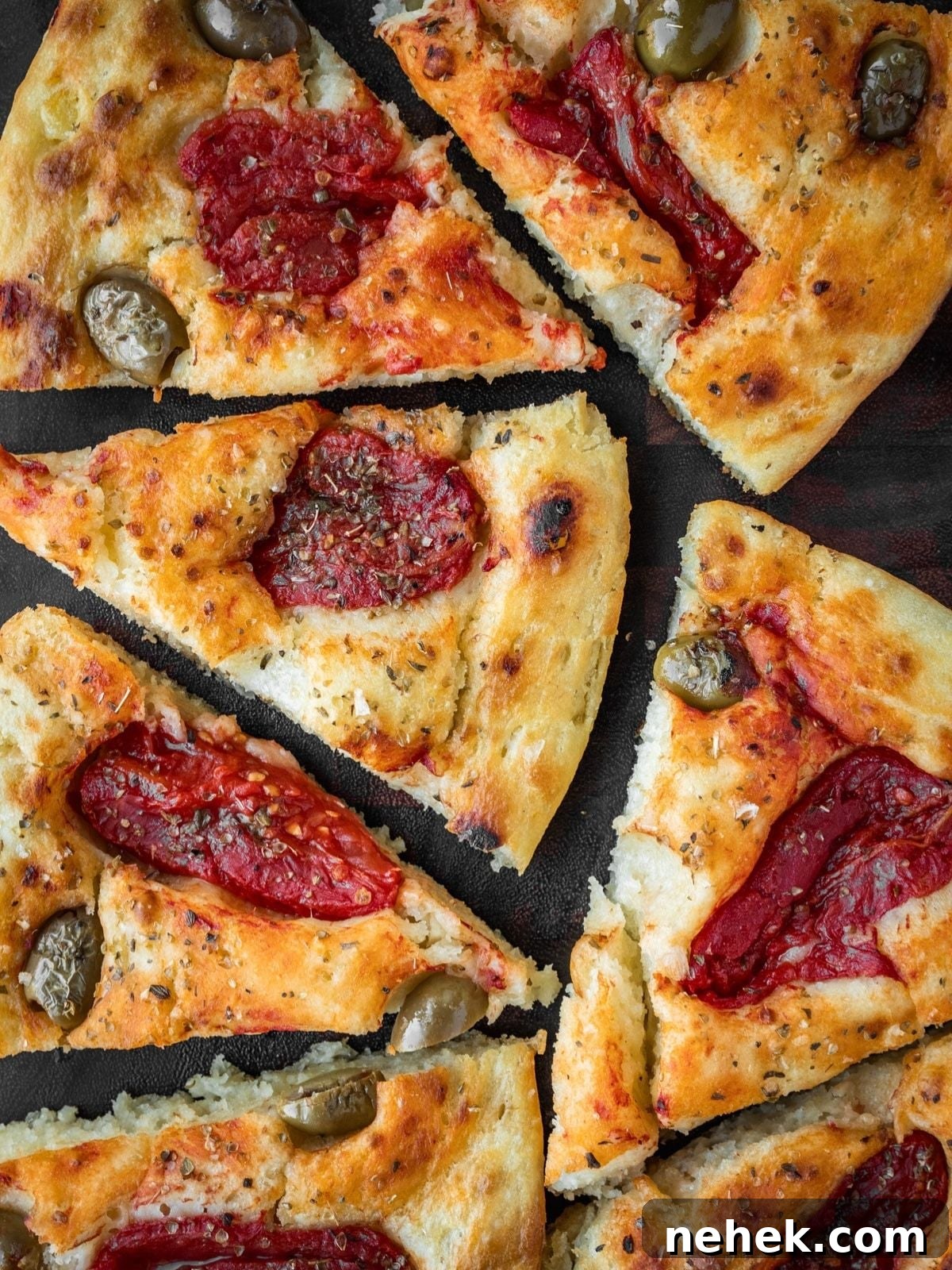Focaccia Barese slices on a wooden board.