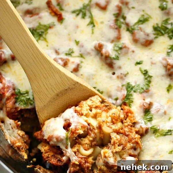 Lasagna in the slow cooker being dished out with wooden spoon