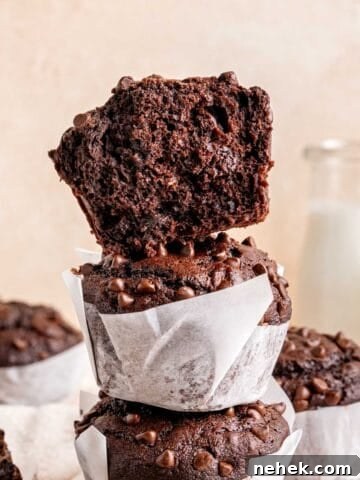 Half of a brownie muffin stacked on whole ones.