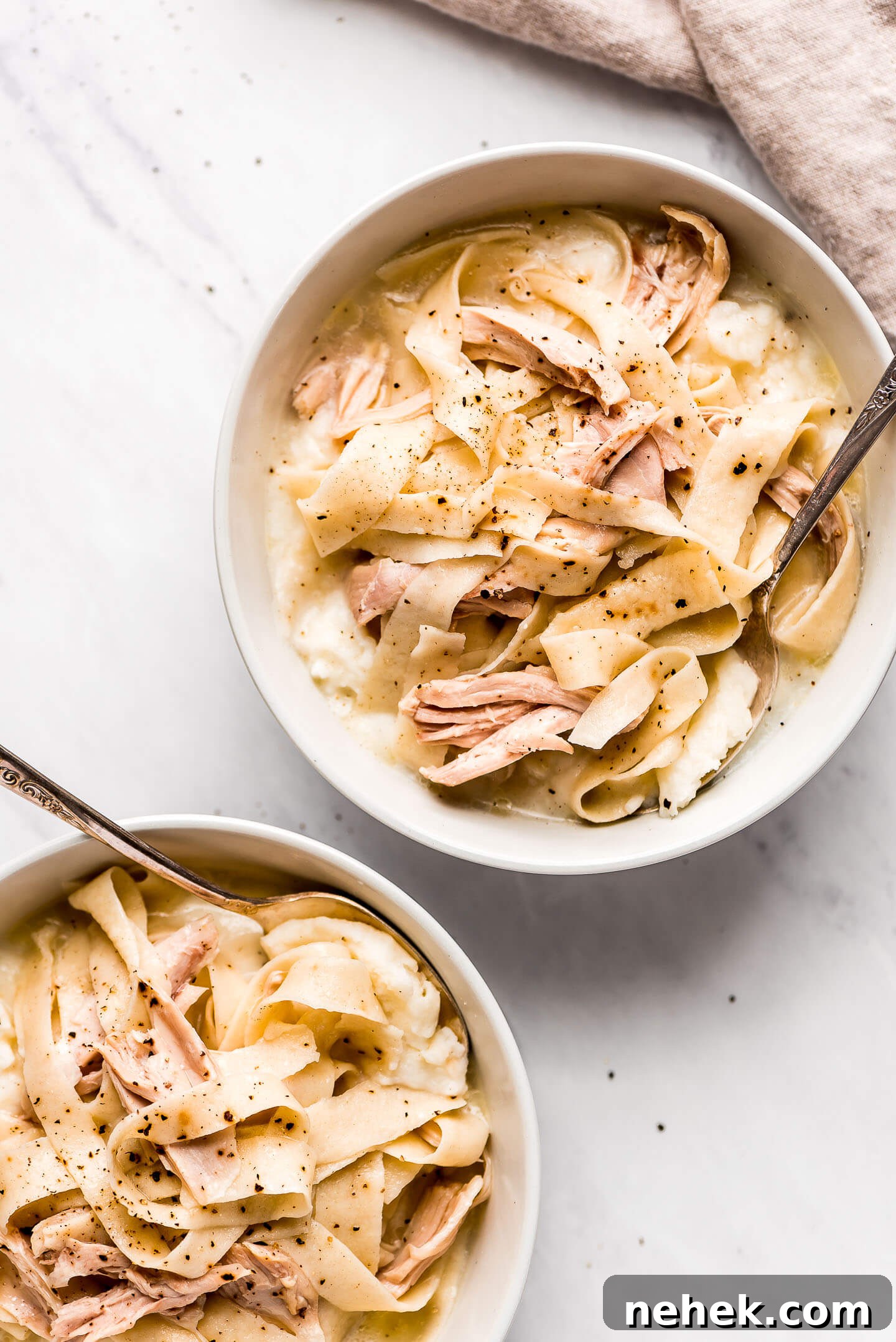 Creamy Chicken and Noodles Served Over Garlic Mashed Potatoes 5 Two bowls of old fashion chicken noodle soup over mashed potatoes.