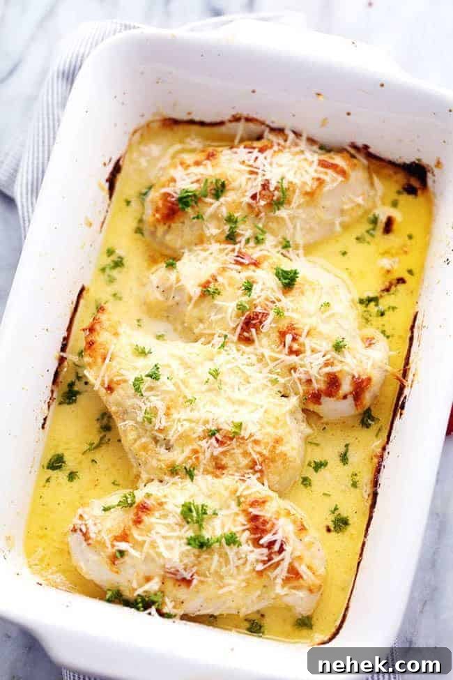 Creamy baked asiago chicken in a white casserole dish. 