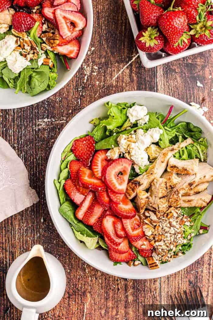 overhead view of keto strawberry chicken salad next to a bowl of fresh strawberries