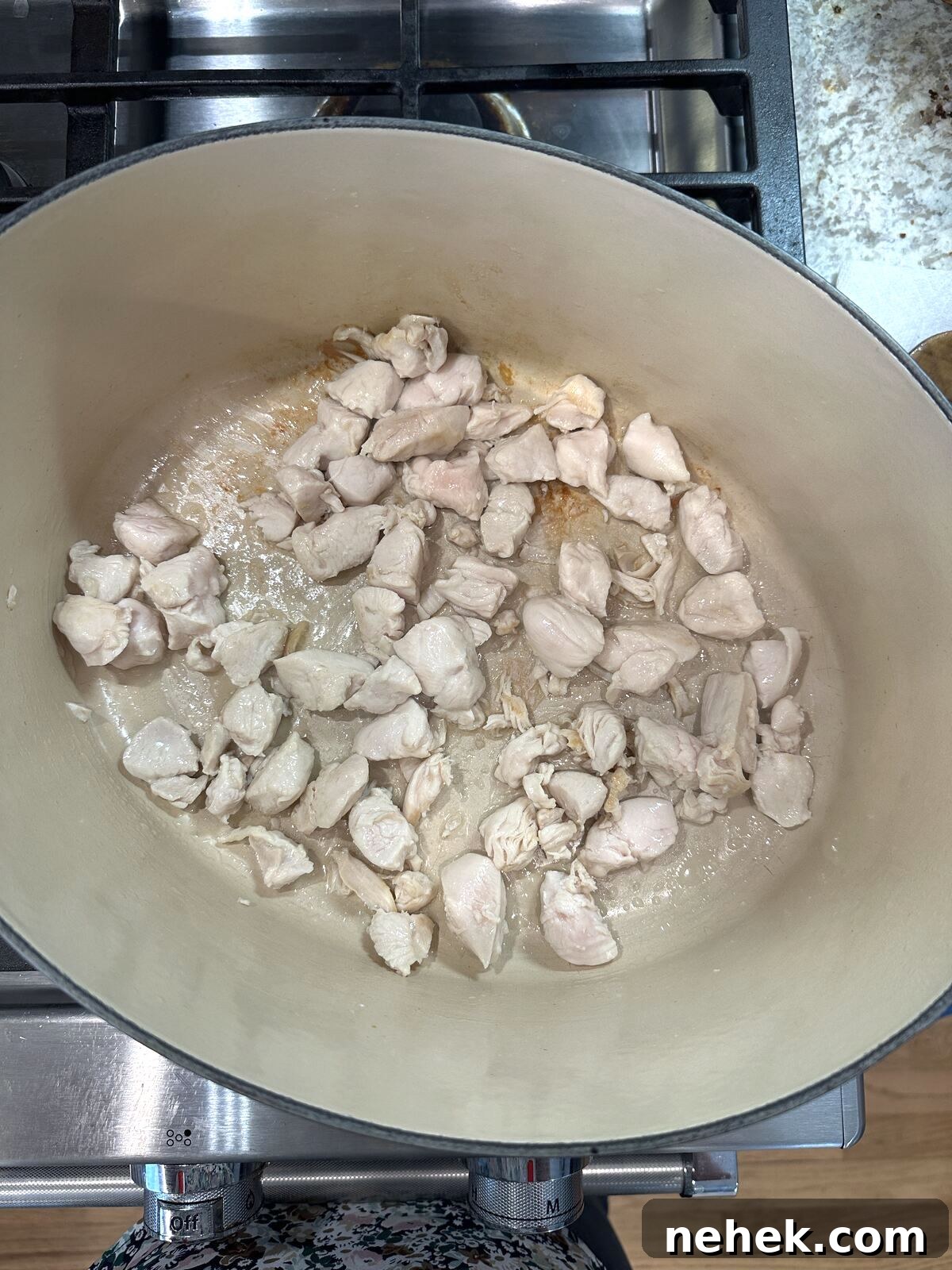 Creamy Corn and Potato Soup Recipe — Comforting Weeknight Soup 5 Chicken for corn soup in a Dutch oven on the stove.