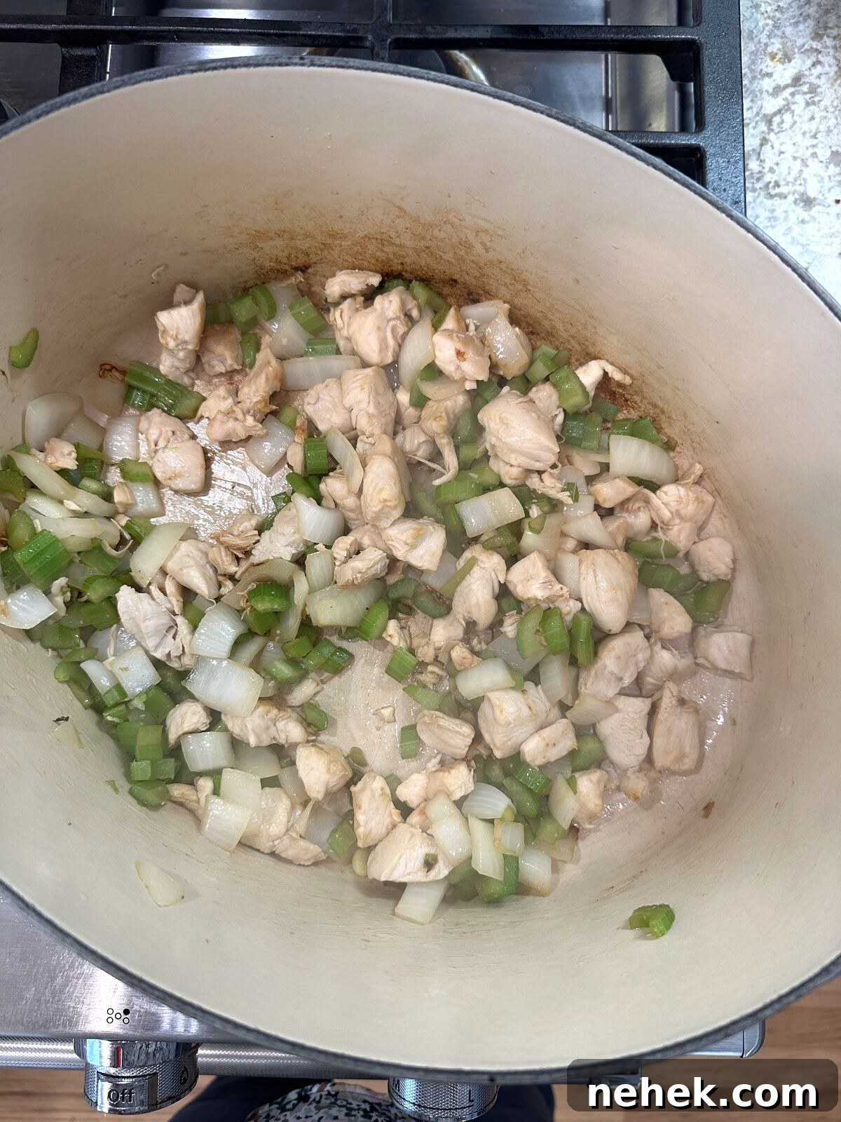 Creamy Corn and Potato Soup Recipe — Comforting Weeknight Soup 6 Chicken, celery and onions in a pan on the stove.