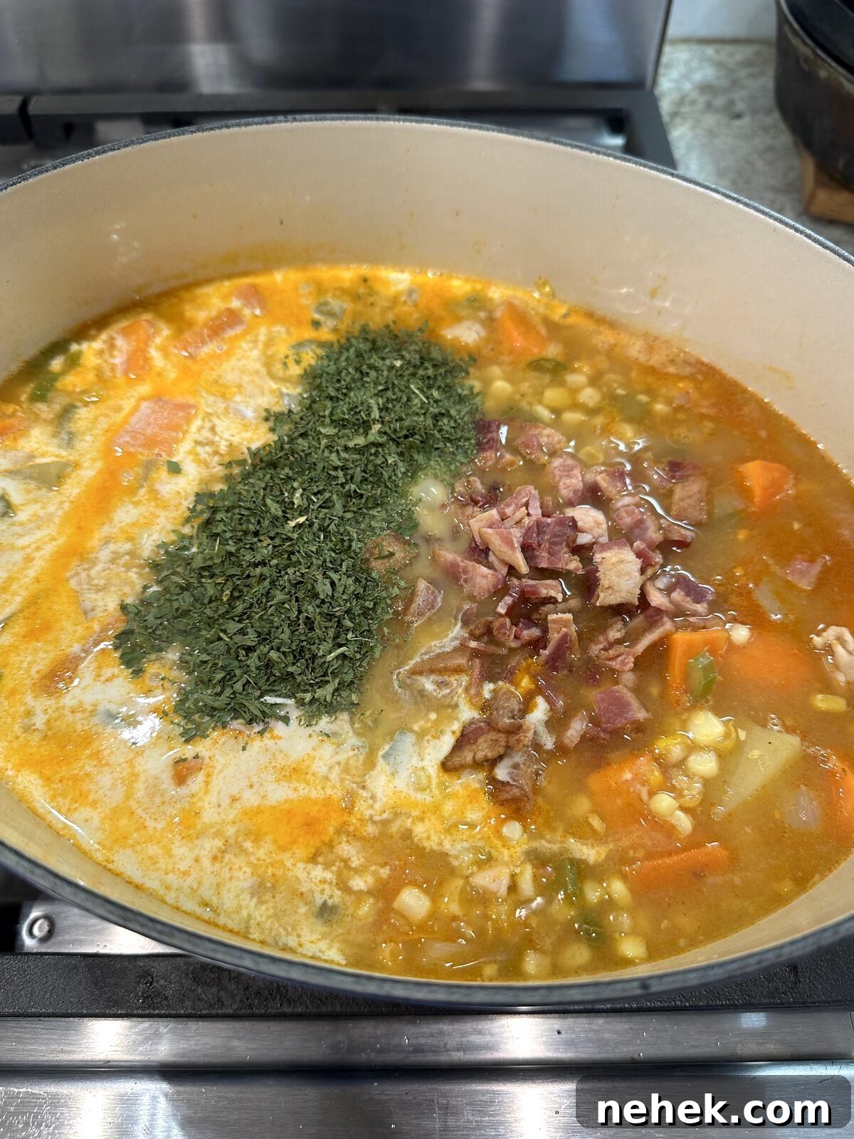 Creamy Corn and Potato Soup Recipe — Comforting Weeknight Soup 9 Corn soup ingredients in a saucepan with bacon and parsley.