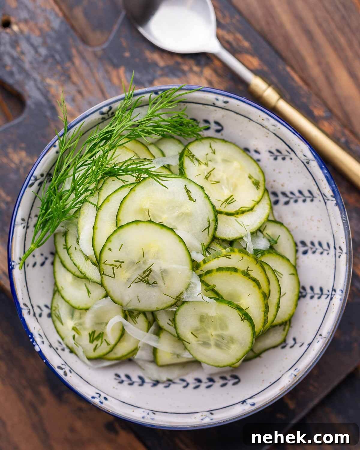Refreshing Cucumber Salad Recipe with Herbs and Vinegar 2 Closeup shot of cucumber salad in blue and white bowl with dill garnish.