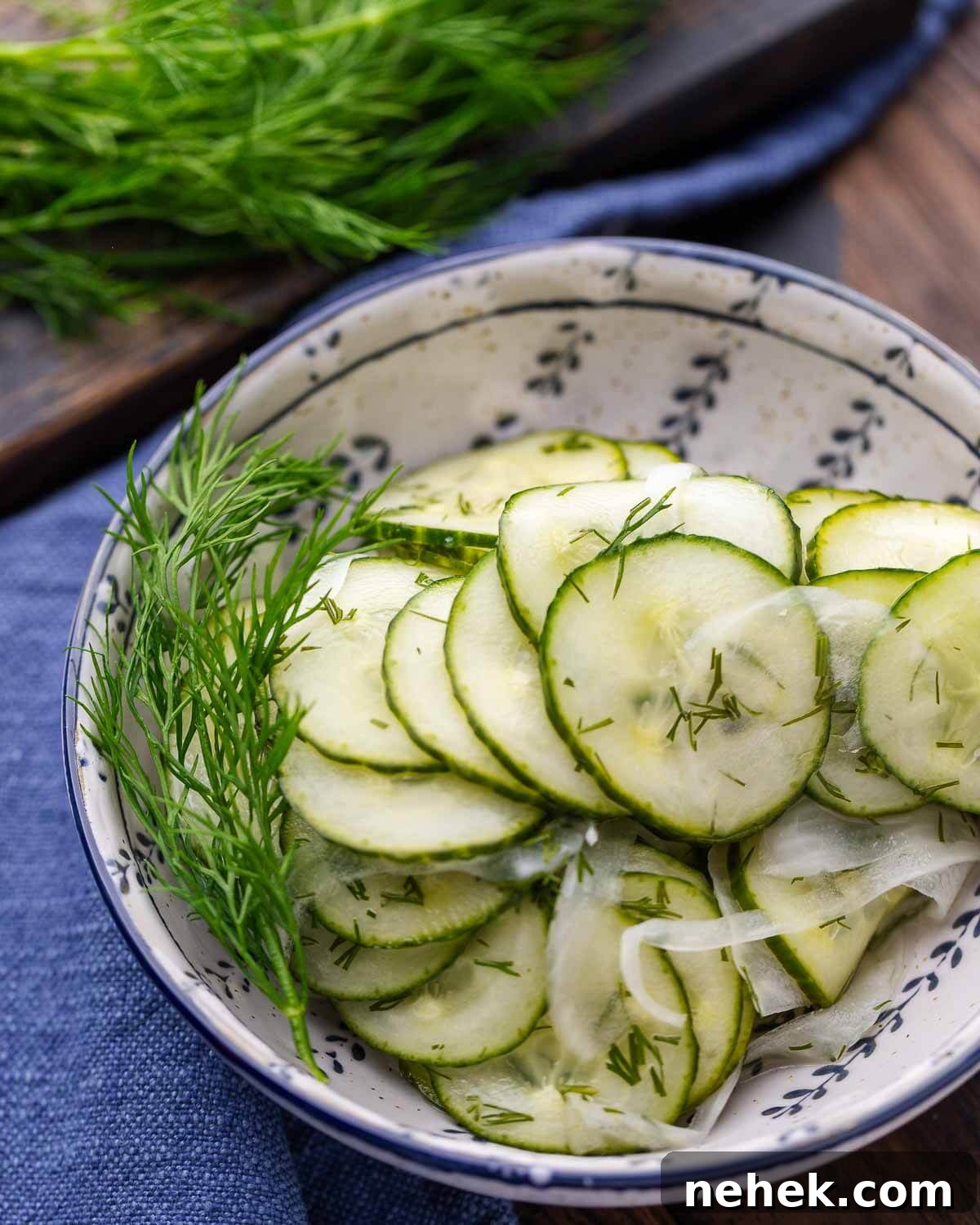 Refreshing Cucumber Salad Recipe with Herbs and Vinegar 7 Closeup shot of cucumber salad in blue and white bowl with blue napkin in background.