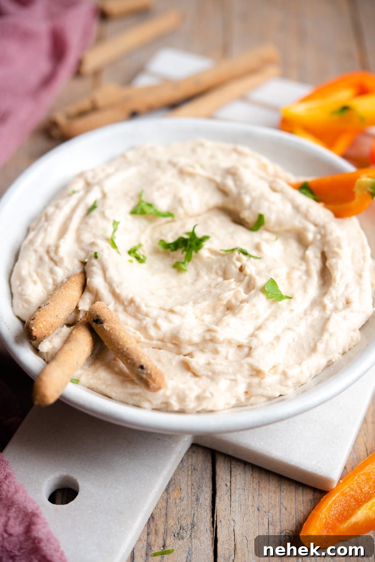 White Bean Dip served with breadsticks and veggies A side shot of a white bean dip with breadsticks and bell peppers around it
