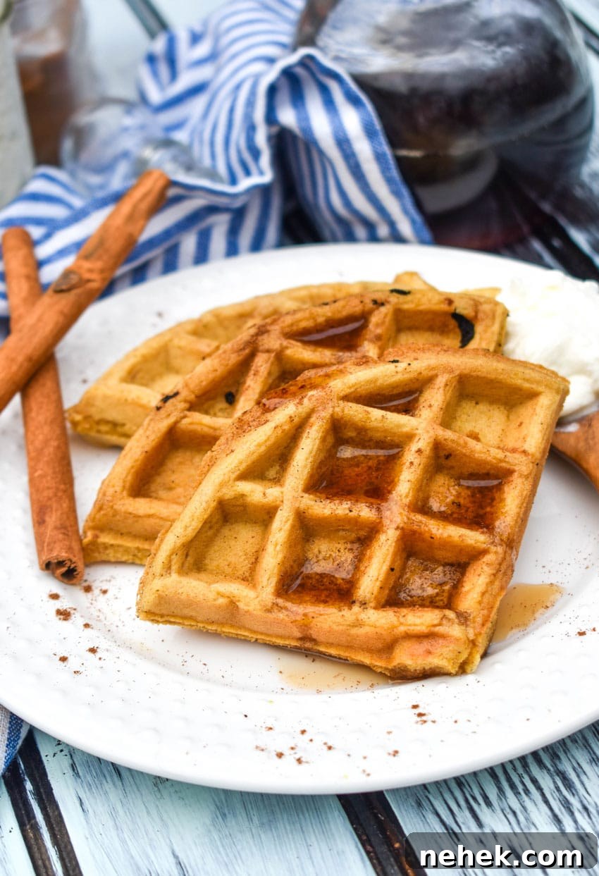 pumpkin spice waffles topped with syrup on a white plate