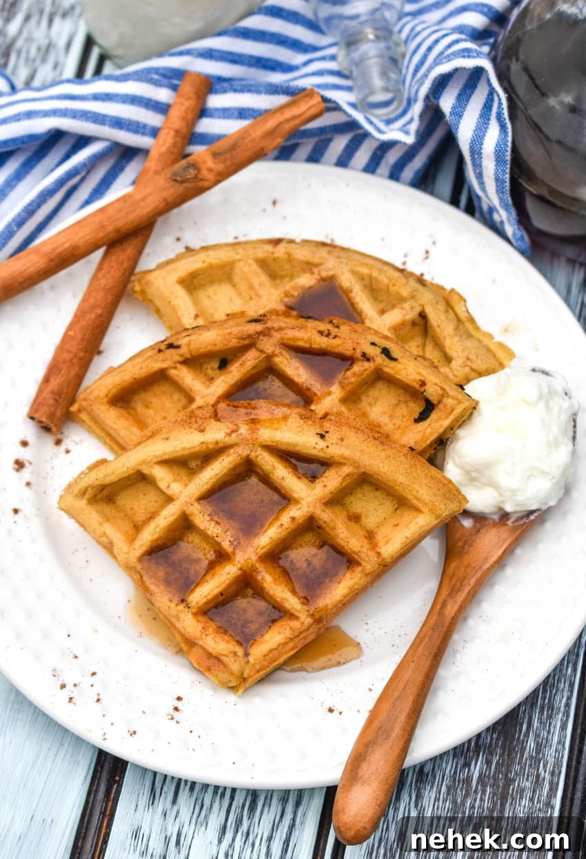 pumpkin spice waffles topped with syrup on a white plate
